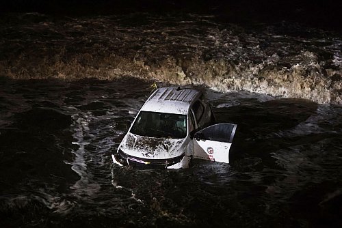 Ein Fahrzeug der Feuerwehr wurde von einer Schlammlawine ins Meer gespült. - © Ethan Swope/AP/dpa