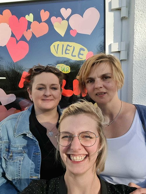 Die Erzieherinnen (von rechts) Anja Brenker, Melanie De Carne und Rita Ratuschnij unterstützen ebenso wie das gesamte Team die Familie und haben für Feelia ein Fenster gestaltet. - © Kita Arche Noah