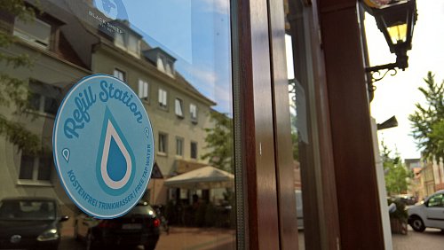 Mit solchen Aufkleber markieren die Refill-Geschäfte, dass sie gratis Wasserflaschen auffüllen. - © Hans-Hermann Igges