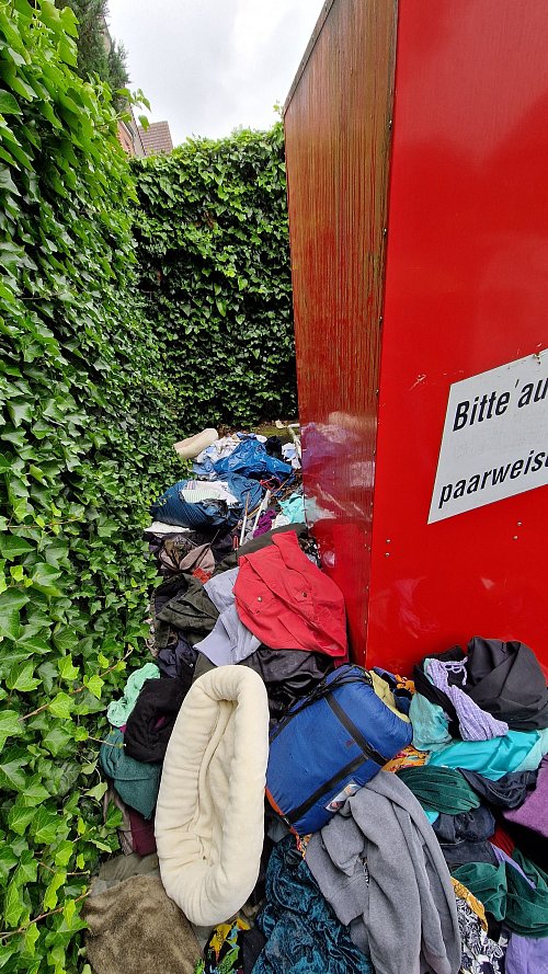 Selbst hinter dem vollen Container werden die alten Kleidungsstücke abgelegt. - © Uwe Pollmeier