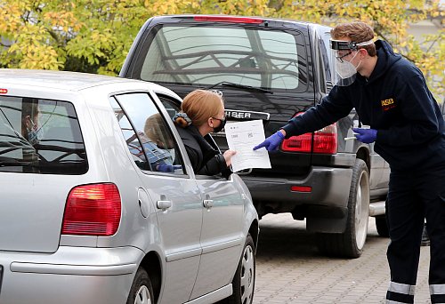 Im Corona-Testzentrum an der Feldstraße reicht Jannes Siek (r.) Leonie Retemeier ein Informationsblatt.  - © Wolfgang Rudolf