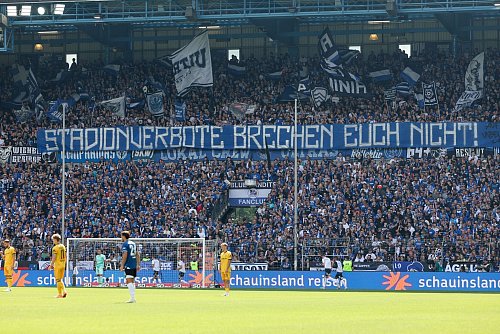 Die Fanszene von Arminia Bielefeld zeigt ein Spruchband zum Thema Stadionverbote. - © Friso Gentsch/dpa