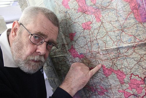 Sperrgebiet: Frank Förste deutet auf der großen Landkarte auf das kleine Borgholzhausen. - © Alexander Heim