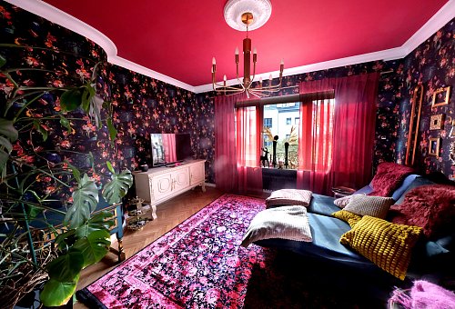 Sabine Schenk liebt Farbe und Muster. Ihr Wohnzimmer hat deshalb eine florale Tapete sowie eine rote Decke bekommen. - © Andreas Frücht