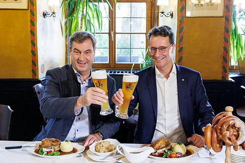 Markus Söder (l.) und Hendrik Wüst (CDU) inszenieren sich bei einem zünftigen Essen in einem fränkischen Restaurant. - © Daniel Karmann/dpa