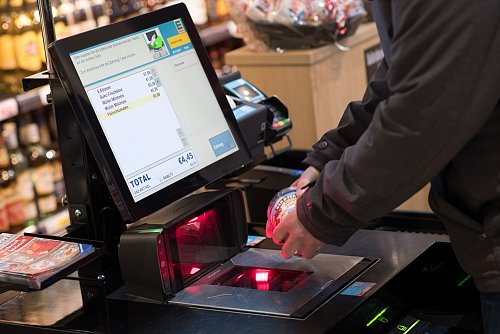 Ein Mann scannt in einem Supermarkt Lebensmittel an einer SB-Kasse. - © picture alliance/dpa