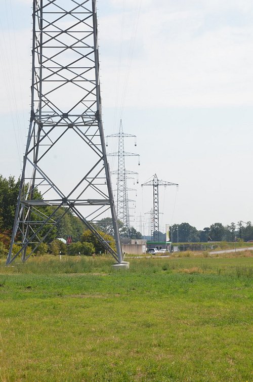 Großer Mast, kleiner Mast: Hier an der Kompostierungslange in Halle-Künsebeck stehen die alten und neuen Masten der Freileitung seit einigen Wochen direkt nebeneinander. So kann sich jeder Interessierte selbst ein Bild davon machen, wie stark sich der Unterschied auswirkt. Foto: Andreas Großpietsch - © Andreas Großpietsch