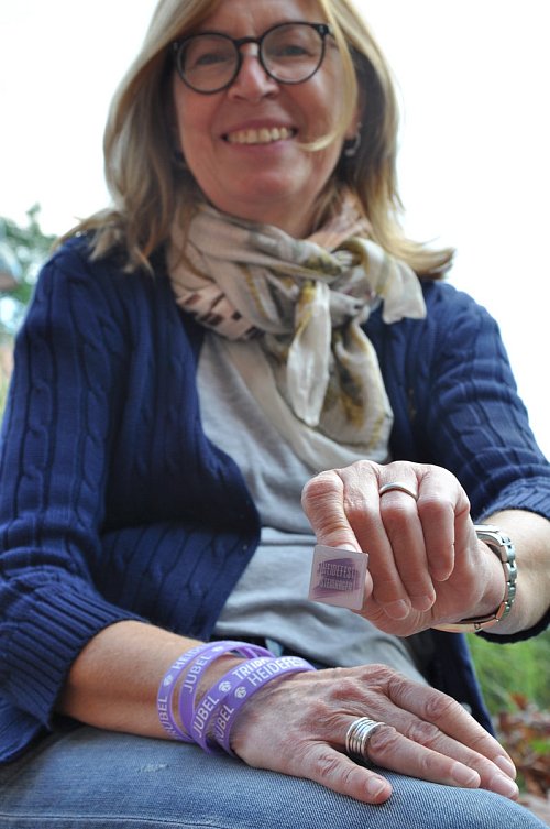 Geschenke: Die Besucher bekommen Armbänder und Anstecker passend zum Event. Petra Holländer präsentiert diese fürs Foto. - © Sonja Faulhaber