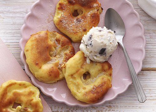 Apfelküchle aus der Heißluftfritteuse – luftig und mit feinem Zimtzucker verfeinert, serviert mit einer Kugel Eis. - © Mathias Neubauer