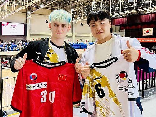 Linus Eggert (l.) machte in der Sporthalle auch viele Bekanntschaften. Auf diesem Foto tauschte er mit einem Chinesen Nationalspieler sein Trikot. - © Linus Eggert
