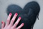 Frauenhand berührt ein auf die Wand gesprühtes Herz - Inga Kjer/dpa/dpa-tmn